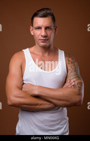 Studio shot of muscular man against brown background Stock Photo