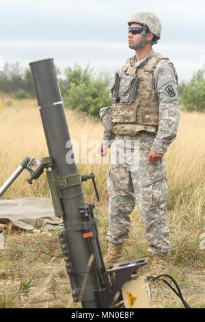 Operation Northern Strike 17 was a large-scale National Guard Bureau exercise conducted in August 2017 at Michigan training ranges for joint and coalition readiness. The archival image documents a soldier scanning a firing lane prior to loading and firing a 120 millimeter mortar during supervised live-fire training. Stock Photo
