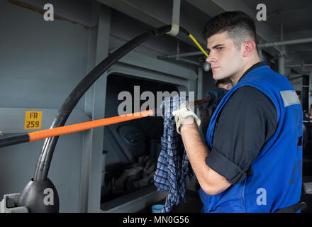 ATLANTIC OCEAN (Aug. 4, 2017) -- Cryptologic Technician (Technical) 3rd Class Tyler Bill, from Auburn, California, assigned to USS Gerald R. Ford's (CVN 78) intelligence department, wipes down the NIXIE torpedo countermeasures system cables during testing operations. Ford is underway conducting test and evaluation operations. (U.S. Navy photo by Mass Communication Specialist 3rd Class Gitte Schirrmacher) Stock Photo