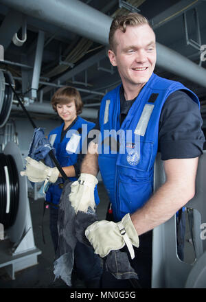ATLANTIC OCEAN (Aug. 4, 2017) -- Cryptologic Technician (Technical) 3rd Class Jacob McGuire (right), from Enon, Ohio, and Cryptologic Technician (Technical) Seaman Hannah McVey, from Pensacola, Florida, assigned to USS Gerald R. Ford's (CVN 78) intelligence department, wipe down the NIXIE torpedo countermeasures system cables during testing operations. Ford is underway conducting test and evaluation operations. (U.S. Navy photo by Mass Communication Specialist 3rd Class Gitte Schirrmacher) Stock Photo