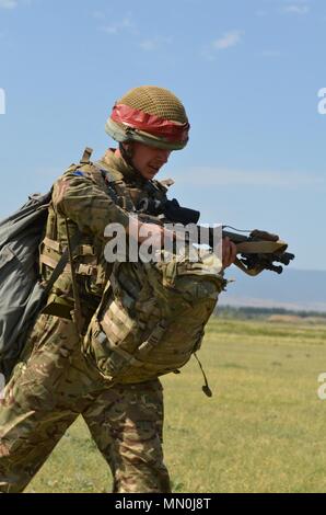 VAZIANI TRAINING AREA, Georgia — British soldier Pvt. Christopher Kantorowicz, 2nd Battalion, Parachute Regiment (2nd PARA), 16th Air Assault Brigade, Essex, England, treks to the collection point with full gear, at the drop zone on Vaziani Training Area, Georgia, Aug. 7, 2017. The red tape signifies first-time jumpers. The 2nd PARA is currently in the Republic of Georgia to participate in Exercise Noble Partner. Noble Partner is a multinational, U.S. Army Europe-led exercise  conducting home station training for the Georgian light infantry company designated for the NATO Response Force. (U.S. Stock Photo