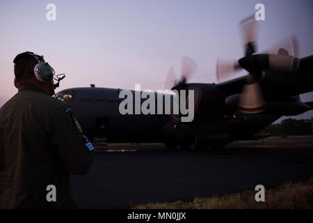 Royal New Zealand Air Force Flight Sgt. Destry Tumataiki, a C-130 Hercules loadmaster assigned to 40th Squadron, RNZAF Auckland, observes engine start ups before a night sortie in support of Exercise Mobility Guardian at Joint Base Lewis-McChord, Wash., Aug. 5, 2017. More than 3,000 Airmen, Soldiers, Sailors, Marines and international partners converged on the state of Washington in support of Exercise Mobility Guardian. The exercise is intended to test the abilities of the Mobility Air Forces to execute rapid global mobility missions in dynamic, contested environments.  (U.S. Air Force photo  Stock Photo