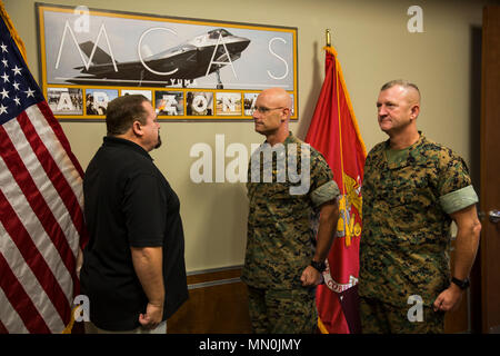 U.S. Marine Corps Col. David Suggs (center) , the commanding officer of Marine Corps Air Station Yuma, Ariz., and SgtMaj. David Leikwold (right), the sergeant major of MCAS Yuma, stand at attention as they recognize Darren Ercanbrack (left), MCAS Yuma’s Air Traffic Control (ATC) supervisor, as the MCAS Yuma Employee of the 3rd Quarter, Aug. 7, 2017. (U.S. Marine Corps photo taken by Lance Cpl. Isaac D. Martinez) Stock Photo