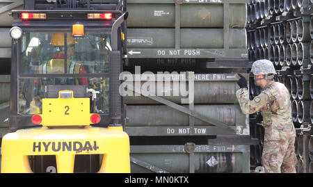 A Soldier assigned to 46th Transportation Company, 194th Combat Sustainment Support Battalion, 501st Sustainment Brigade, 19th Expeditionary Sustainment Command assists a Ammunition Supply Point personnel in downloading a multiple launch rocket system training pod during a proof of principle loading exercise at Camp Kwangsari, Yangju, South Korea, Aug. 3, 2017. The joint exercise was designed to train and test Soldiers with rapid and effective loading procedures and cooperation with various units. (U.S. Army Photo by Sgt. Michelle U. Blesam, 210th FA Bde PAO) Stock Photo