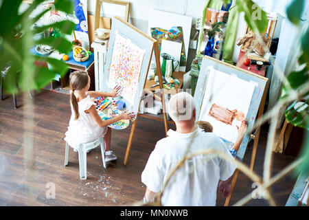 Boy and girl drawing on easels in art class Stock Photo - Alamy