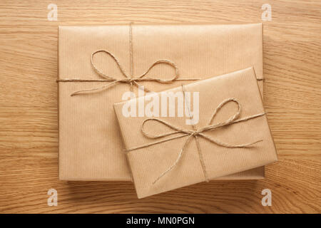 Two gift boxes wrapped in kraft paper on wooden table Stock Photo