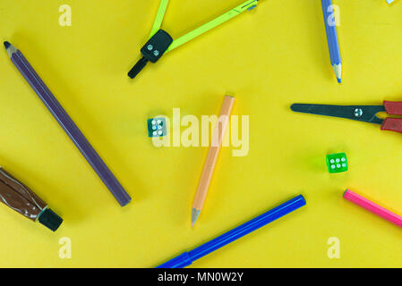 A group of school objects on yellow background. And dices. Stock Photo
