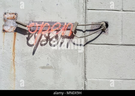 red neon sign that says open in script Stock Photo