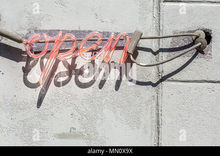 red neon sign that says open in script Stock Photo