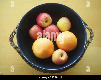 Blue fruit bowl with five apples and two grapefruit Stock Photo
