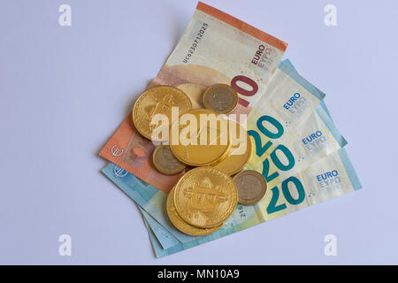 Euro bills and cryptocurrency coins piled on a white background Stock Photo