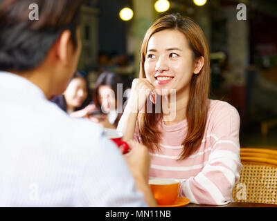 young asian couple lovers sitting at table chatting talking face to face in coffee shop. Stock Photo