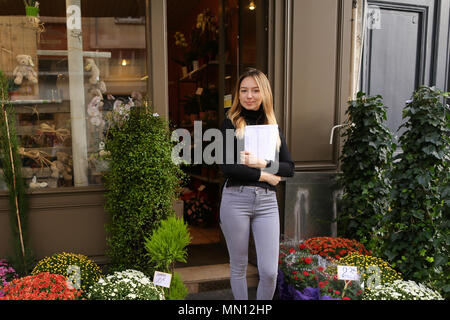 Female manager of flower shop standing with papers. Stock Photo