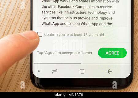 A man confirming his age on the Terms and Privacy Policy page of the Whatsapp app on a smartphone Stock Photo