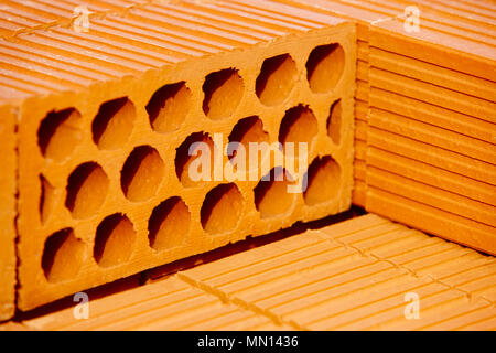 Stacked orange bricks. Construction industry. Building pieces. Horizontal Stock Photo