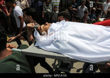 GAZA, PALESTININ TERRITORIES - 13 MAY 2018 Mourners carry the body of 15-old Palestinian Jamal Afana, during his funeral in Rafah in the southern Gaza Strip, on 13 May 2018. Jamal who was shot in the head by Israeli forces during clashes along the border near Rafah in southern Gaza on May 11, succumbed to his wounds the next day, the Hamas-run ministry said. © Abed Rahim Khatib / Awakening / Alamy Live News Stock Photo