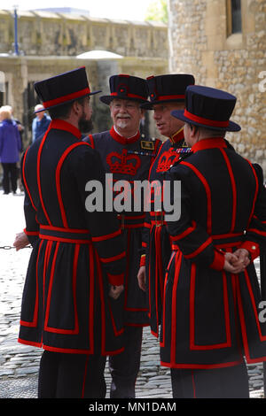 London, UK. 13th May, 2018. Yeoman Warders talking amongst themselves shortly before the ceremony of the 'Stela' at HM Tower of London.  The Stela is a piece of medieval water pipe made from a hollowed tree trunk. It is delivered annually to the Governor of the Tower (for safekeeping) by members of the Company of Watermen and Lightermen who row the Queen’s barge, 'Gloriana', carrying the Stela, from Hampton Court Palace to the Tower along the Thames. Credit: Michael Preston/Alamy Live News Stock Photo