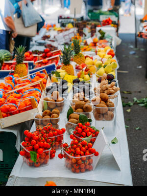 Rows of fresh fruits for sale at a market stall - selective focus on tomatoes on foreground. Stock Photo