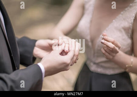 symbol of the beginning of family life: the couple exchange wedding rings Stock Photo