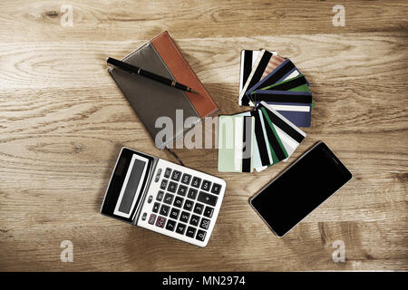 calculator, pen, notebook and bank discount and credit cards on a wooden background Stock Photo