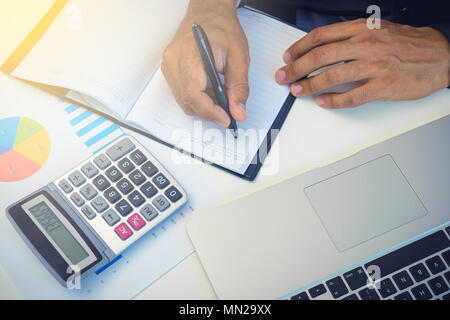 Businessman accouting management with calculator marketing report taking note balance of money statement on paperwork in office Stock Photo