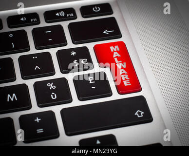 Red button with Malware word on the keyboard close-up. Stock Photo