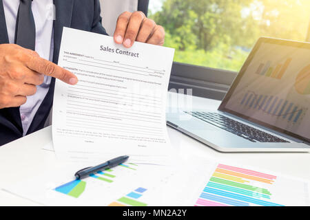 Business young man agent showed the sales contract and pointing it at the desk in office Stock Photo