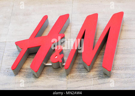 Hannover, Germany - May 8, 2018: H&M logo sign on facade of local fashion chain store of global multinational retail company Hennes and Mauritz. Stock Photo