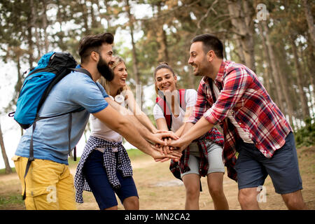 Group of happy young hikers in forest Stock Photo