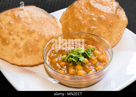 Delicious Chole Bhature ( spicy white Chick Peas) Indian Punjabi Cuisine served in Glass bowl on white background in India Stock Photo