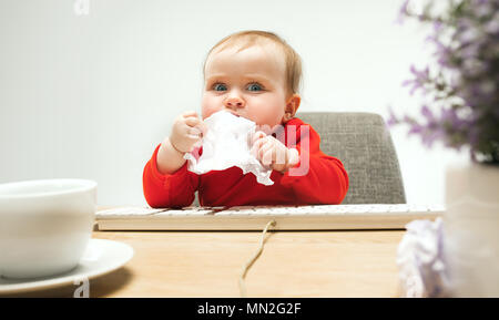 Happy child baby girl toddler sitting with keyboard of computer isolated on a white background Stock Photo