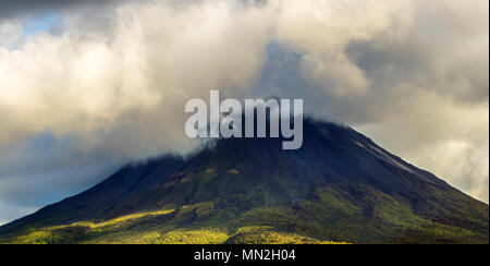 Cloud-topped Arenal Volcano National Park. Active volcano in Costa Rica with visible lava flow from 1968 eruption. Stock Photo