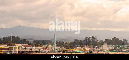 Santa Cruz Beach Boardwalk in springtime, with a view of the Santa Cruz Mountains. Northern California, USA. Stock Photo