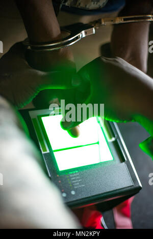 U.S. Army Reserve Soldiers from the 351st, 800th, and 160th Military Police Companies operate a digID Mini 10-print fingerprint device to process simulated detainees during Combat Support Training Exercise 86-17-02 at Fort McCoy, Wisconsin, on August 18, 2017. The exercise integrated joint forces in realistic detention and biometric enrollment scenarios. The archival image documents the application of biometric identification equipment in a field training setting. Stock Photo