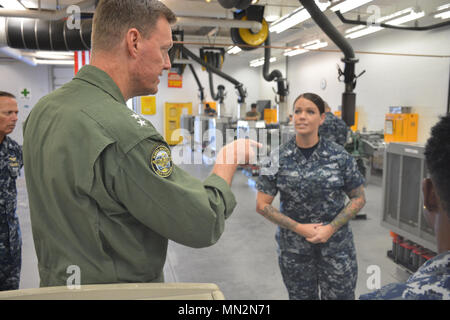 PENSACOLA, Fla. -- Commander, Naval Education and Training Command (NETC) Rear Admiral Kyle Cozad (right) receives a brief on Naval Air Technical Training Center (NATTC) Aviation Support Equipment 'A' School  courses Aug. 18 during Cozad's familiarization tour of Center for Naval Aviation Technical Training (CNATT) commands aboard Naval Air Station Pensacola, Florida. Stock Photo