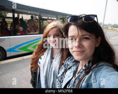 Two young ladies waiting for a bus Stock Photo