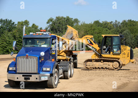 Construction workers operate heavy equipment while removing debris near the intersection of Nelson Dr. and SAC Blvd. August 17 on Offutt Air Force Base, Nebraska. They are constructing a road that will provide additional access to a new dormitory being built next to Tuskegee Hall. The dormitory is scheduled for completion in February 2019. (U.S. Air Force photo by Delanie Stafford) Stock Photo