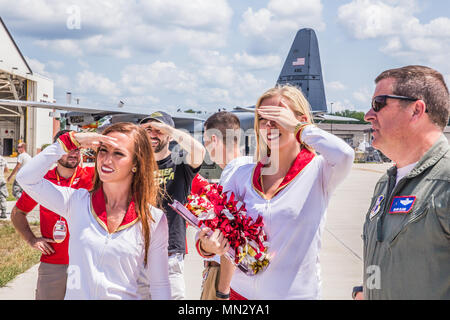 Jenni (left) and Sara, cheerleaders for the Kansas City Chiefs NFL team, watch a C-130 Hercules perform air drop operation in the distance, during a tour of Rosecrans Air National Guard Base, St. Joseph, Mo. Aug. 15, 2017. The visit was part of a McDonald’s Restaurant Heart of America Co-Op 15-stop tour for local charities. Retired Chiefs players Tony Adams and Gary Spani were in attendance as well as current cheerleaders of the team. (U.S. Air National Guard photo by Staff Sgt. Patrick Evenson) Stock Photo