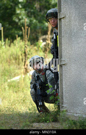 Army Reserve Soldiers assigned to the 693rd Quartermaster Company, Bell, California, check around a corner while moving through a mock village during Combat Support Training Exercise 86-17-02 at Fort McCoy, Wisconsin, from August 5 – 25, 2017. Thousands of Army Reserve Soldiers joined service members from different service branches to train in a large-scale exercise focused on multi-echelon and multi-functional, realistic, tactical training to challenge and improve the proficiency of leader and collective tasks. One of the key focuses of the CSTX was to return to, and understand basic Soldier  Stock Photo