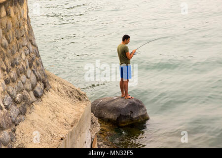 Man fish with spinning tackle on wooden pier. Fisherman cast fishing rod in  lake or river water. Adventure, sport, activity. Spin fishing, angling, ca  Stock Photo - Alamy