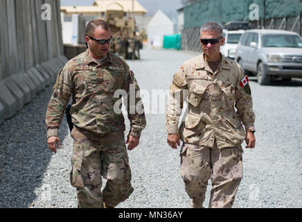 Canadian Army Chief Warrant Officer Paul Francis, the senior enlisted leader of the NATO Allied Joint Force Command, right, takes a walking tour of Forward Operating Base Oqab with U.S. Air Force Chief Master Sgt.  Shane Wagner, the command chief master sergeant of the 438th Air Expeditionary Wing, Aug. 29, 2017, in Kabul, Afghanistan. Francis visited Train, Advise, Assist Command-Air to learn more about the mission of air advisors and support personnel who work to expand the capabilities of the Afghan Air Force. (U.S. Air Force photo by Staff Sgt. Alexander W. Riedel) Stock Photo