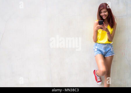 Beautiful teenager girl wearing vibrant yellow shirt Stock Photo