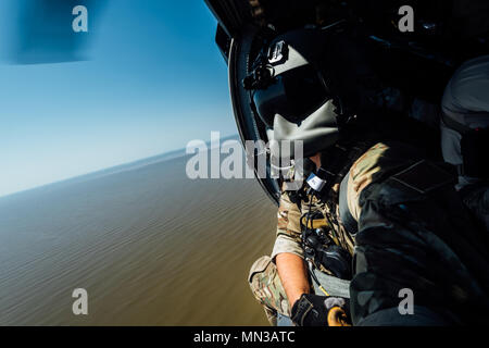 Senior Airman Austin Hellweg, 129th Rescue Squadron special missions aviator, looks out the side door of a HH-60 Pavehawk on the way to aide in the relief effort for Hurricane Harvey, Aug. 31st, 2017, over Texas. The relief efforts have a conglomerate of active, guard and reserve units from all branches aiding the federal government to help Texas recover from Hurricane Harvey. (U.S. Air Force photo by Staff Sgt. Jordan Castelan) Stock Photo