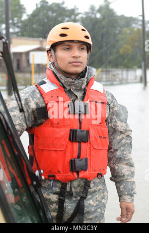 Spc. Alberto Trejo, 386th Engineer Battalion, Texas Army National Guard, looks out over severe flooding in Cypress, Texas, August 27, 2017. Texas Guardsmen partnered with first responders from Texas Task Force One and the Cypress Creek Fire Department to move residents from severely flooded neighborhoods to safety days after Hurricane Harvey hit south Texas. (U.S. Army National Guard photo by Capt. Martha Nigrelle) Stock Photo