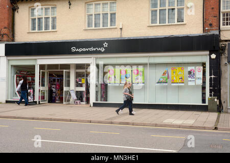 People walking past a Superdrug store in Hitchin town centre, Hertfordshire, England Stock Photo