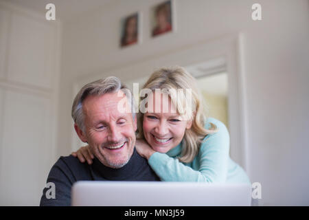 Smiling, happy mature couple using laptop Stock Photo