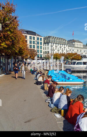 Lucerne, Switzerland - October 19, 2017: Swiss students eat lunch and study on the Reuss River embankment Stock Photo