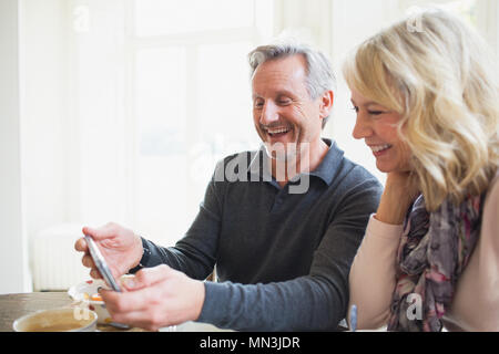 Smiling mature couple using smart phone Stock Photo