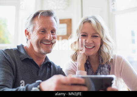 Smiling mature couple using smart phone Stock Photo