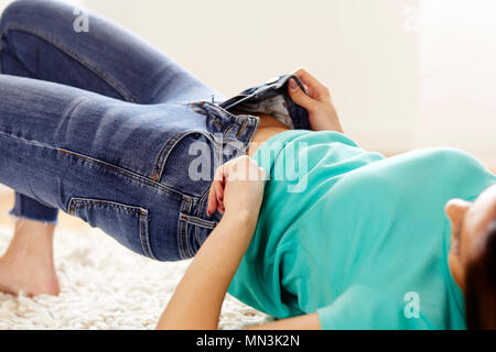 Girl pulling up tight fitted jeans